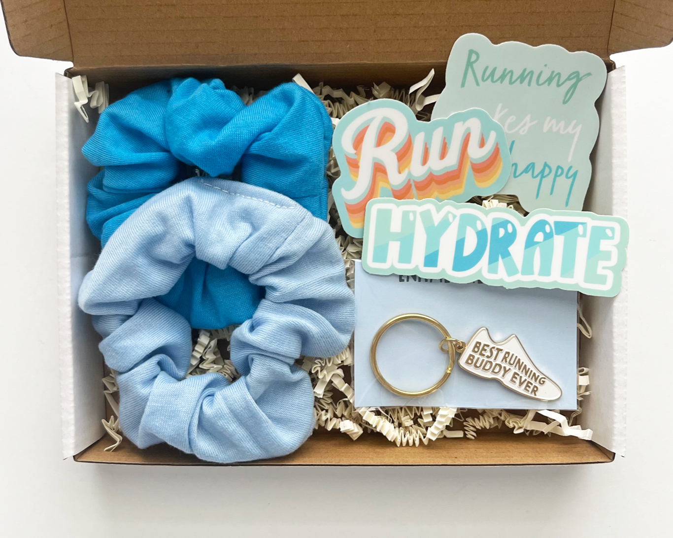 open running buddy gift box with 2 blue hair ties, 2 stickers and running buddy keychain