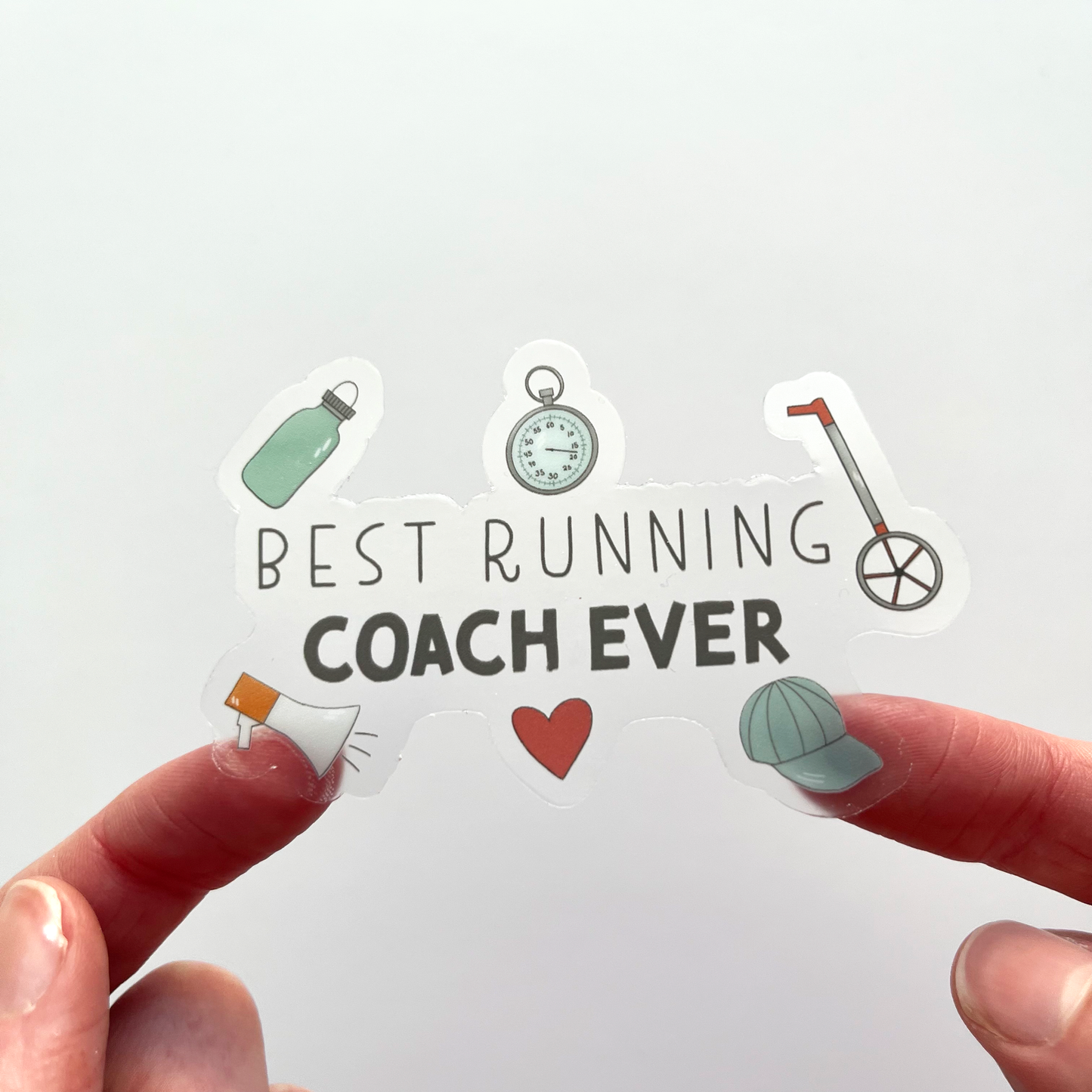 Clear best running coach ever sticker with various objects surrounding the text like water bottle, baseball hate, measuring sticker, megaphone, stop watch and a heart