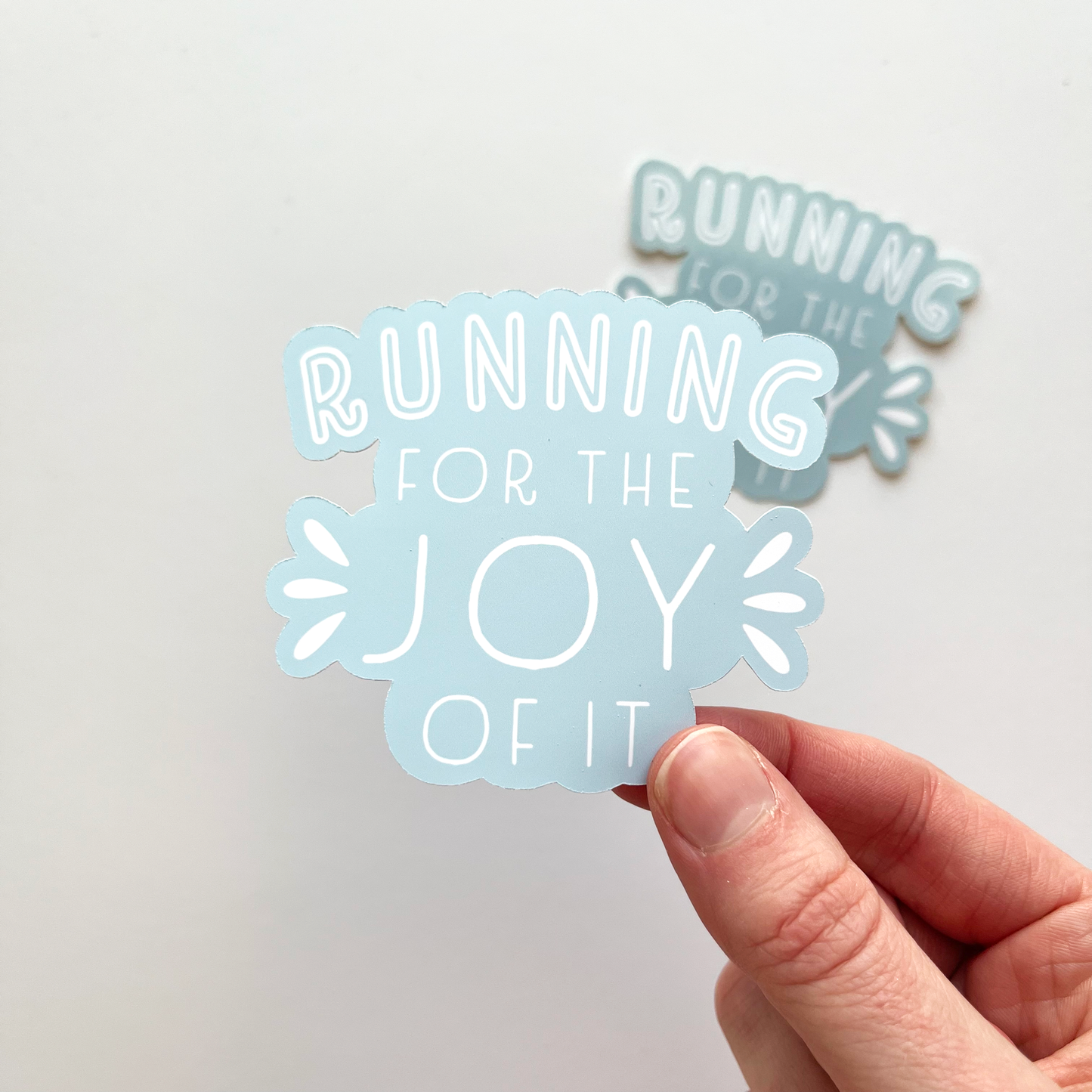Running For The Joy Of It Sticker with white text and a light blue background