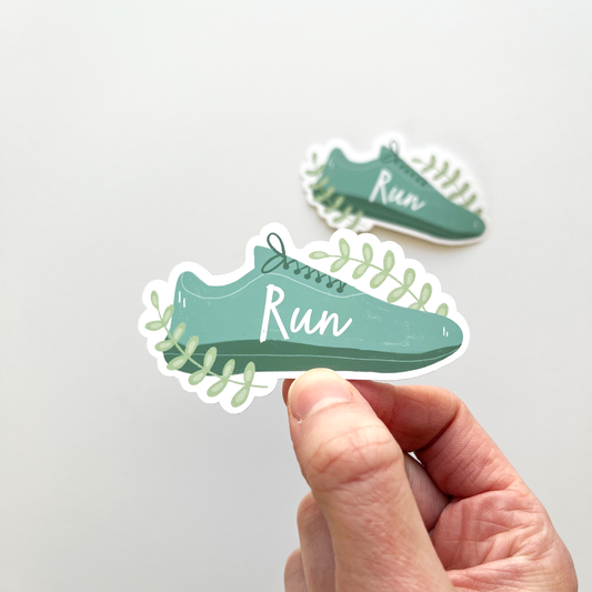 Teal shoe sticker with word runner on the inside and two branches of greenery on outside of the shoe