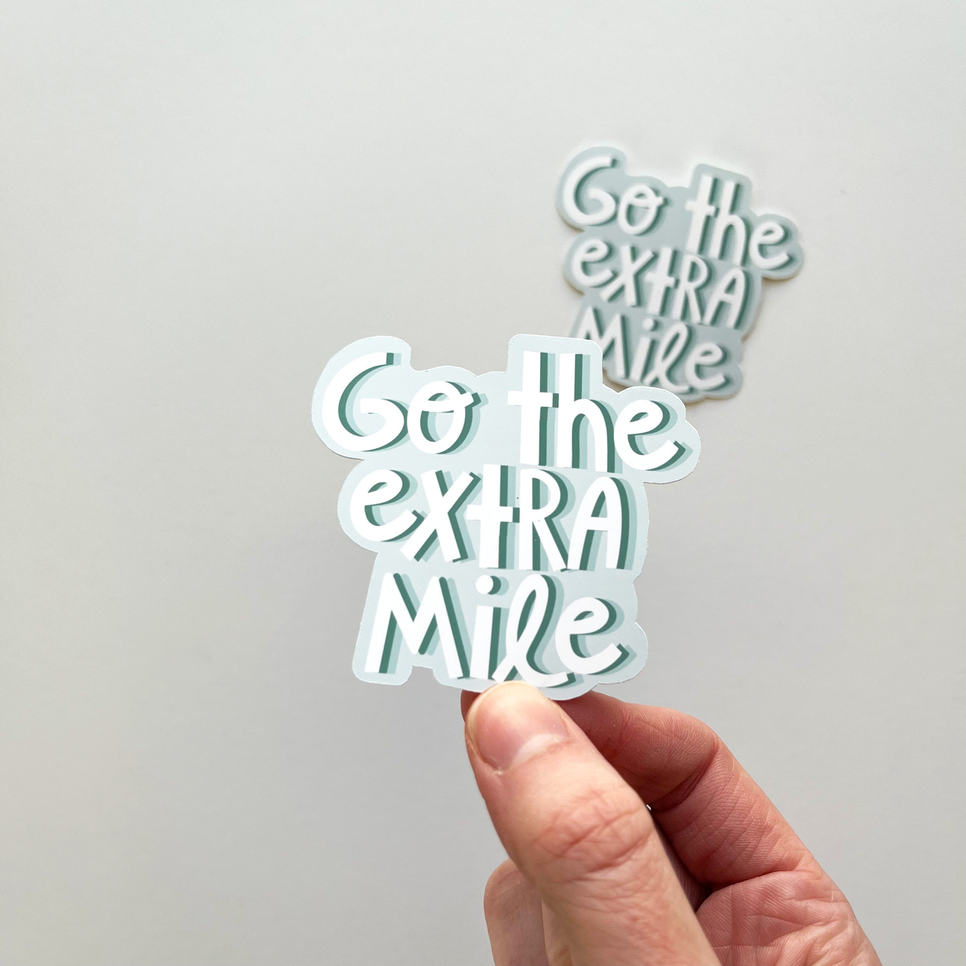Go the extra mile sticker in colors of teal and blue