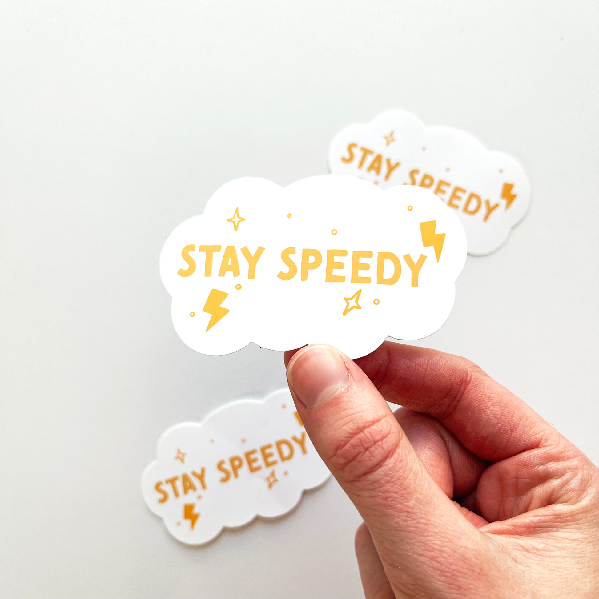 Stay speedy sticker shaped as a white cloud with yellow text and accents of tiny lightning bolts and stars