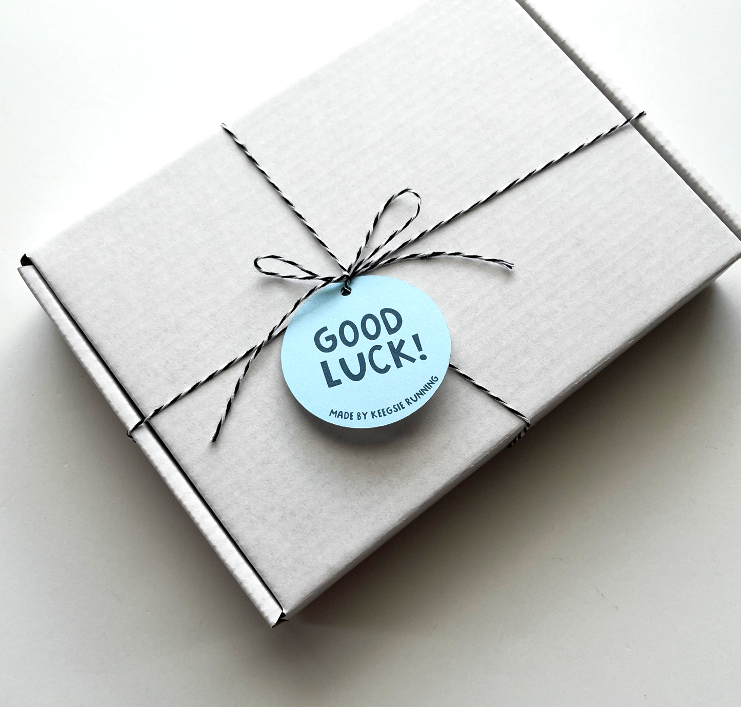 white closed gift box tied with twine and good luck tag