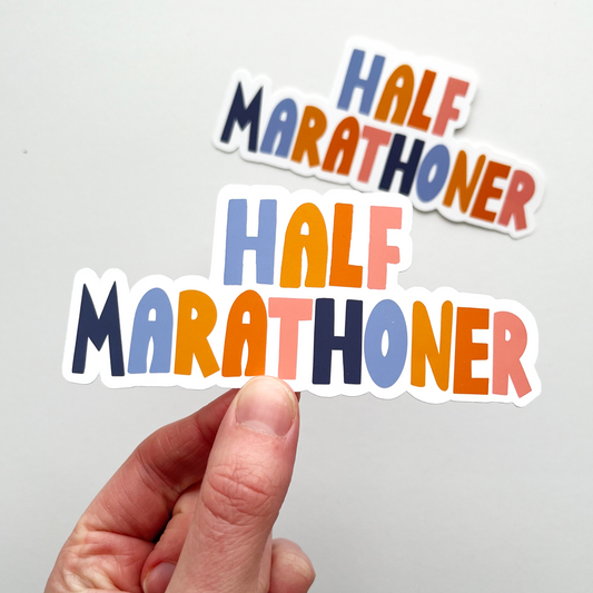 half marathoner sticker with letter alternating colors of blue, light orange, dark orange, pink and dark blue.