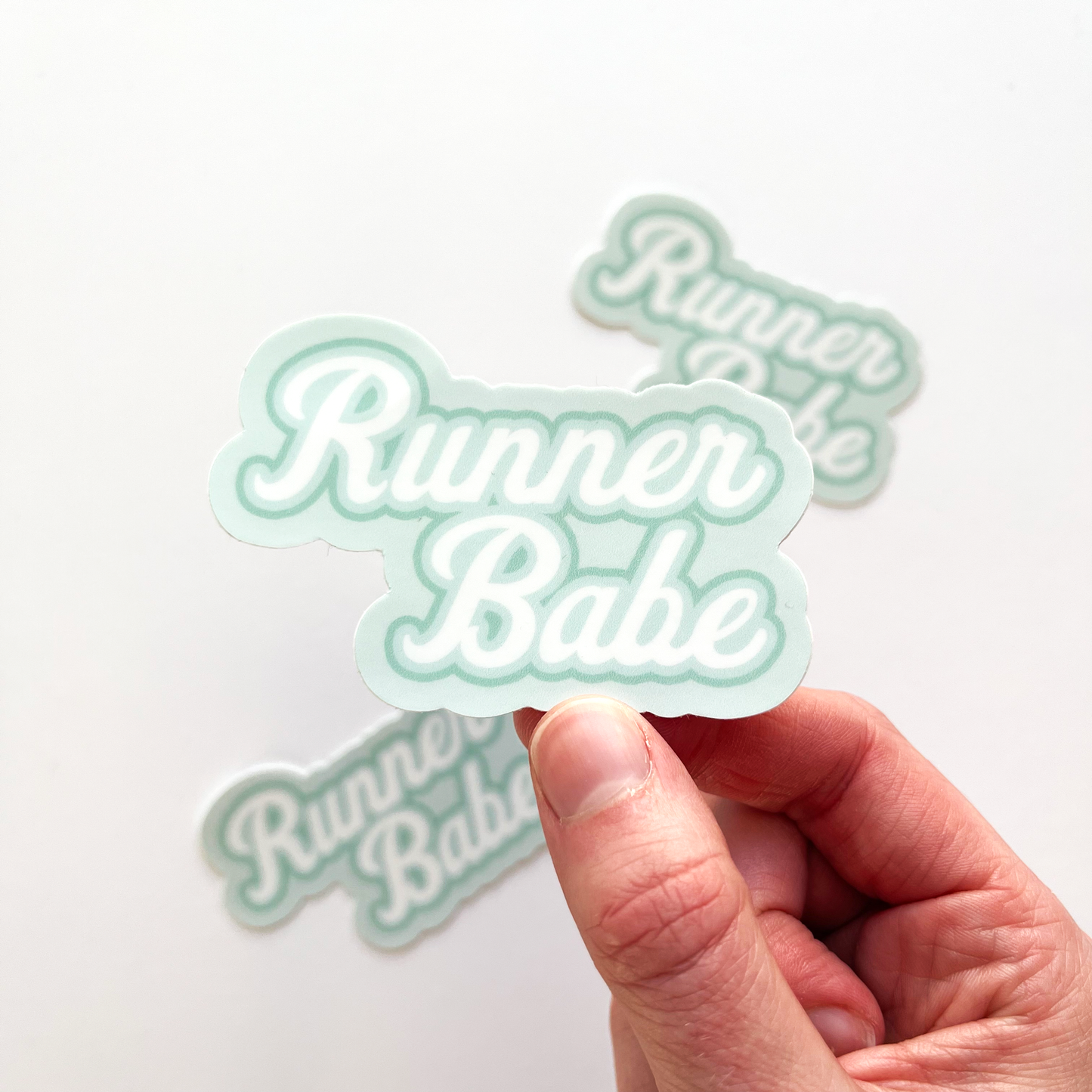Runner babe sticker with white text and outlined in teal and blue